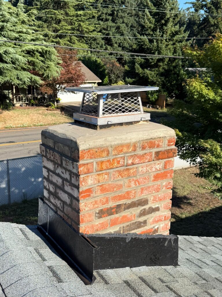 Brick chimney with a small metal chimney cap installed.