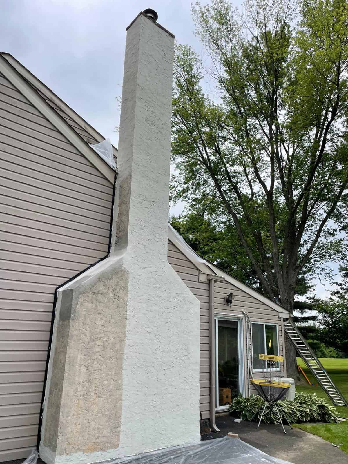 Large chimney with three exposed round flue openings before cap installation.